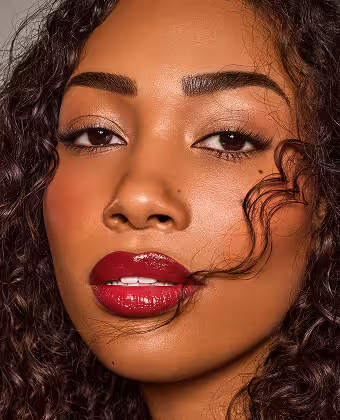 Close-up einer Frau mit Locken und rotem Lippenstift