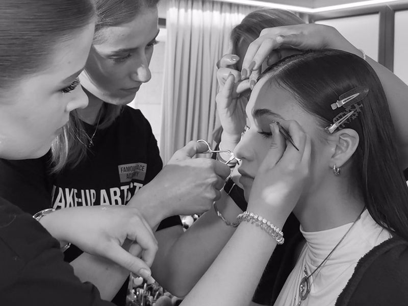 Schülerinnen der Famous Face Academy schminken ein Model